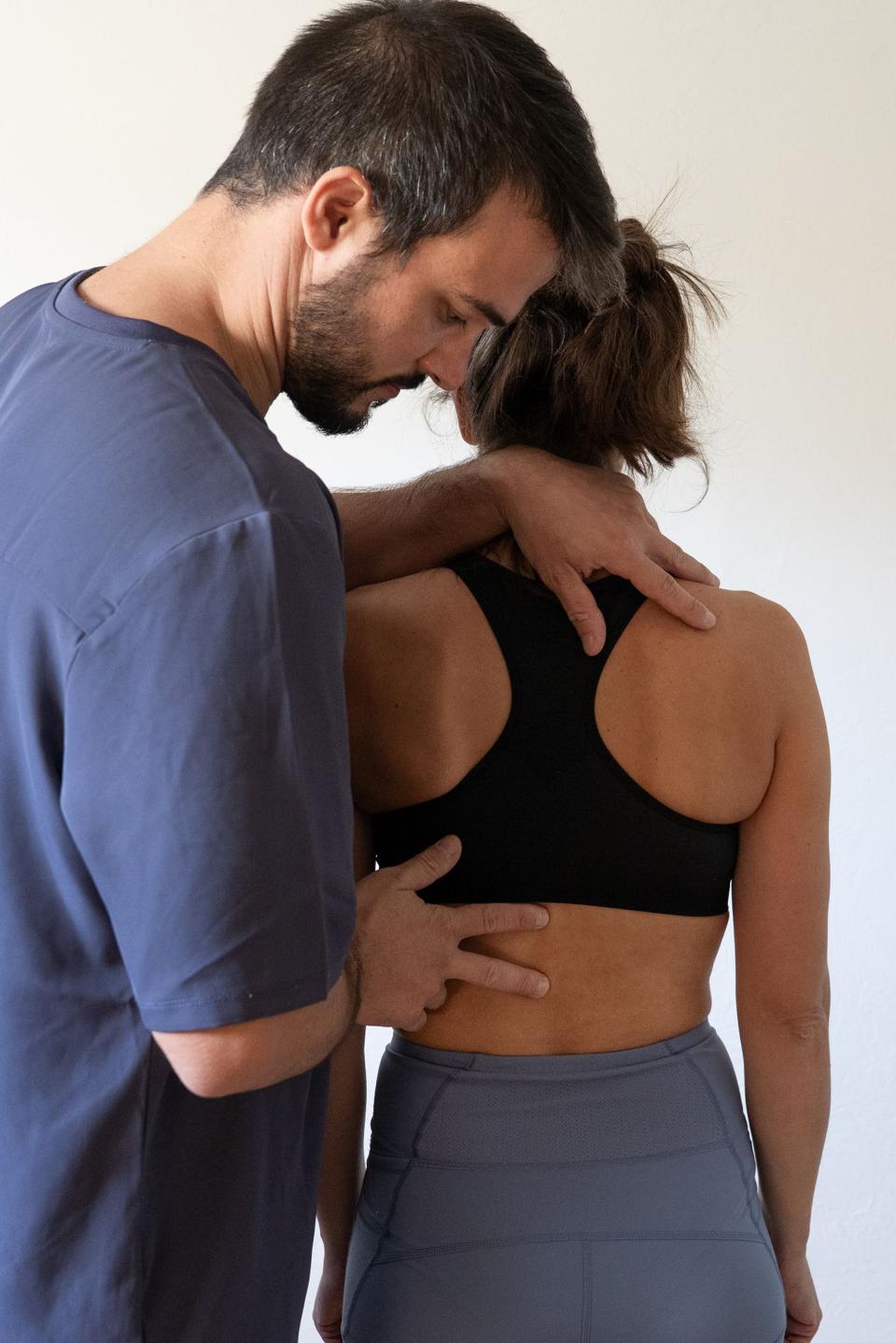 Valutazione osteopatica in piedi, con le mani su spalla e schiena